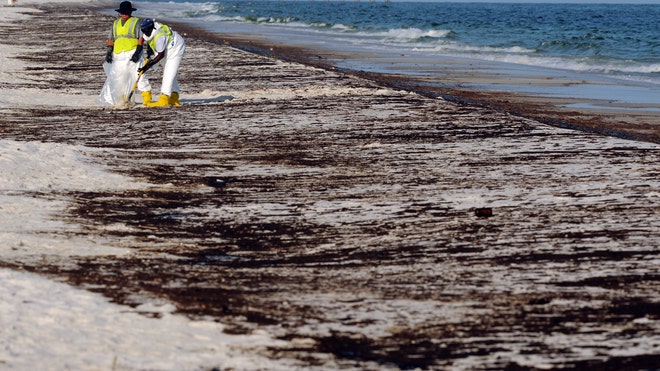 Crews clean up oil from the Deepwater Horizon spill at Pensacola Beach